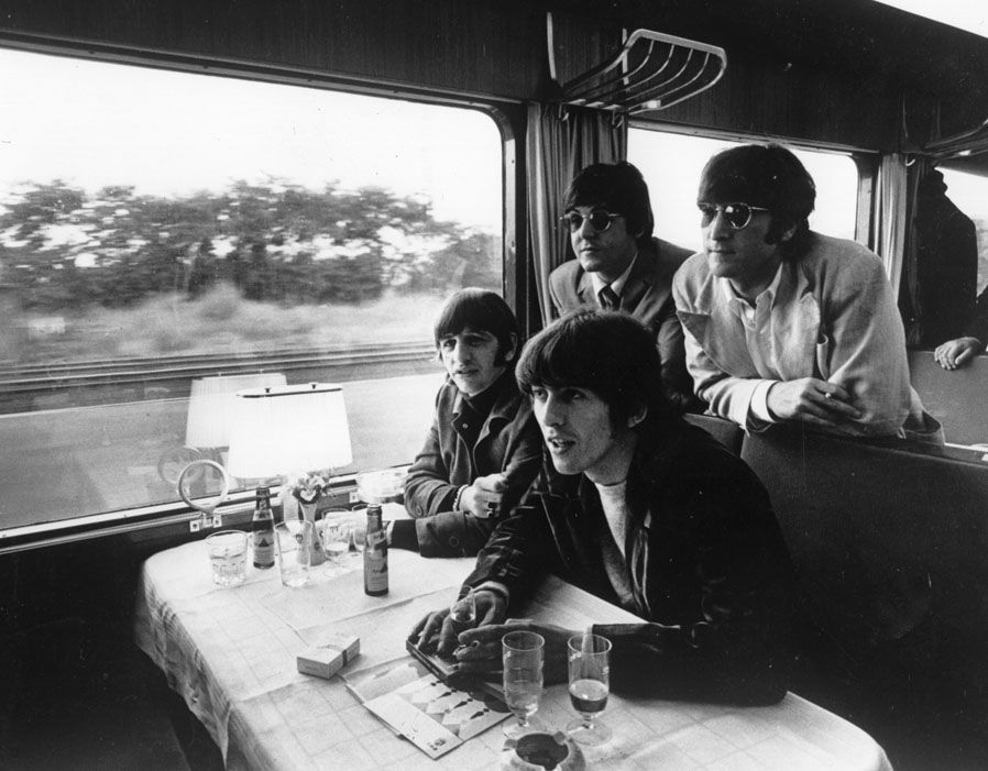 The BEatles pose on a train